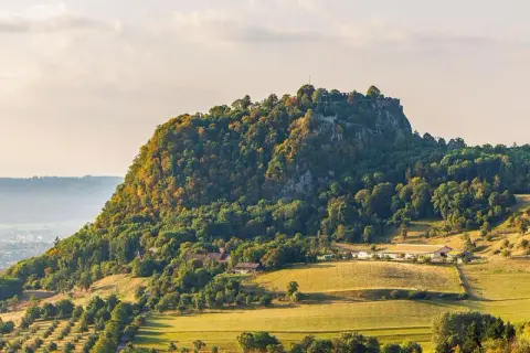 Burgruine Hohenzollern, ein Wahrzeichen Deutschlands, thront auf einem bewaldeten Berg. Die Landschaft um Singen, Deutschland, ist im Herbstlicht malerisch.