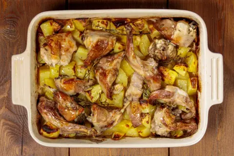 Coniglio ripieno al forno con patate, dorato e profumato, pronto per essere gustato.
