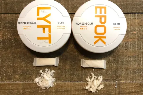 Två dosor snus, LYFT och EPOK, med tillhörande portionspåsar och lössnus. LYFT hette tidigare EPOK.