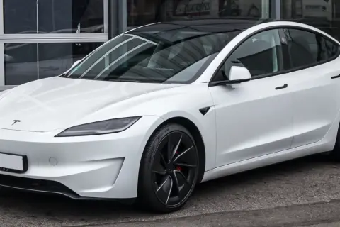 Tesla Model 3 blanco con techo negro. Su diseño aerodinámico sugiere una gran autonomía, optimizando la capacidad de la batería para viajes largos.