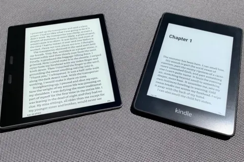 Deux liseuses Kindle affichent des livres. L'une montre un texte en anglais, l'autre un chapitre. Idéal pour la conversion epub azw3.
