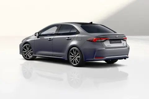 Szary sedan Toyota Corolla GR Sport z czarnym dachem i sportowymi felgami, prezentujący dynamiczną sylwetkę.