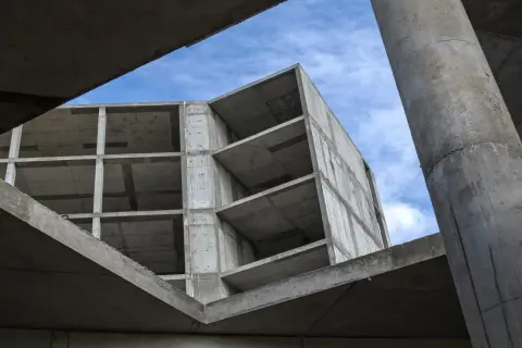Budowa z betonu, widok od dołu na niebo i konstrukcję.