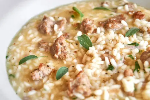 Cremiges Risotto mit herzhaften Salsiccia-Stücken und frischen Salbeiblättern.