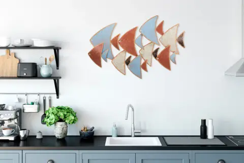 Décoration murale cuisine : un banc de poissons stylisés aux couleurs pastel et terreuses orne le mur blanc au-dessus d'un évier moderne.