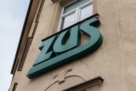 Zielone logo ZUS na budynku. Czekam na przelew, kiedy ZUS wypłaca chorobowe.