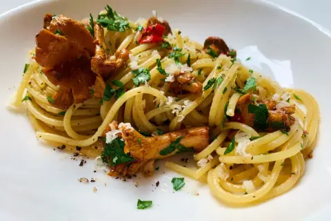 Pfifferling Nudeln mit frischer Petersilie und Parmesan. Ein köstliches Gericht, das den Geschmack des Waldes auf den Teller bringt.