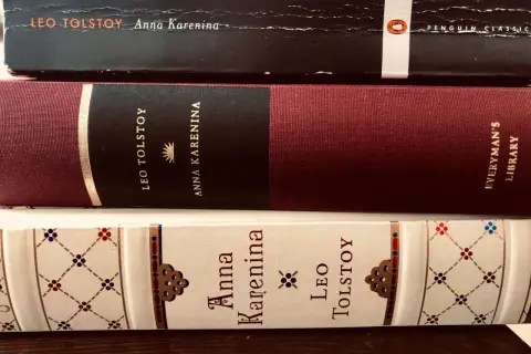 Trzy oprawione książki z tytułem "Anna Karenina" i nazwiskiem Lwa Tołstoja.
