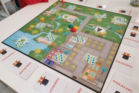 Kolorowa plansza do gry z motywem miasta i śladami łapek, idealna na gry planszowe dla 6 osób.