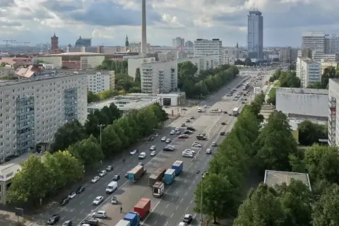 Blick über die Stalinallee in Berlin mit ihren charakteristischen Plattenbauten und viel Verkehr.