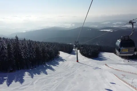 Widok z kolejki linowej na ośnieżony stok narciarski. Sprawdź jańskie łaźnie ski cennik i zaplanuj swój wyjazd!