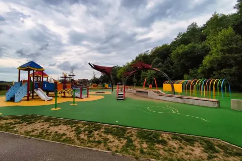 Kolorowy plac zabaw z mnóstwem atrakcji dla dzieci w Rzeszowie: zjeżdżalnie, huśtawki, tunele i ścianki wspinaczkowe.