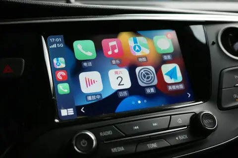 Ekran samochodu z ikonami Apple CarPlay. Jak włączyć tę funkcję? Zobaczysz tu telefon, muzykę, mapy i inne aplikacje.