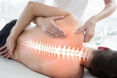 Hände eines Therapeuten behandeln den Rücken eines Mannes. Die Wirbelsäule ist hervorgehoben. Ein visueller Hinweis auf den Unterschied zwischen Osteopathie und Chiropraktiker.