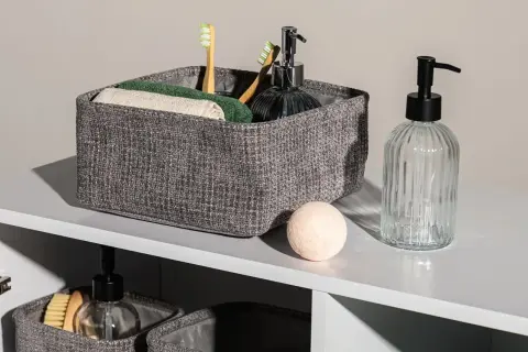 Eleganckie koszyki do łazienki z bambusowymi szczoteczkami, ręcznikami i dozownikiem mydła.