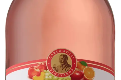 Butelka Carlo Rossi Pink Moscato z owocami: brzoskwiniami, winogronami, jabłkiem i pomarańczą.