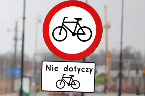 Dwa znaki drogowe: okrągły z rowerem i przekreślonym, oraz prostokątny z napisem "Nie dotyczy" i rowerem. Różne rodzaje znaków informują o zakazie ruchu rowerowego.