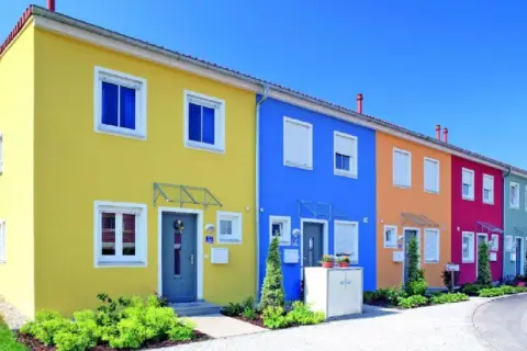 Reihenhäuser in leuchtenden Farben: Gelb, Blau, Orange, Pink. Tolle hausfassade farbe ideen für ein fröhliches Zuhause.