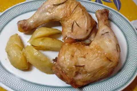 Cosce di pollo dorate e patate a spicchi, un piatto perfetto preparato nella friggitrice ad aria.