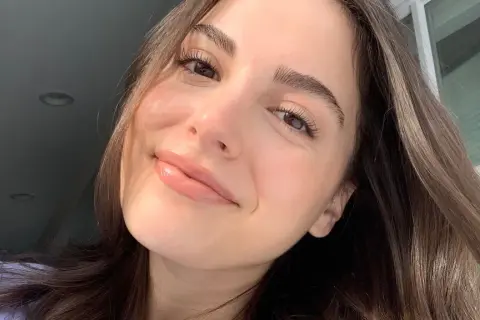 Una mujer sonríe con una piel luminosa y un brillo natural.