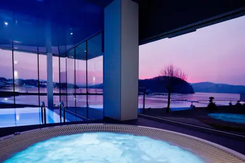 Relaks w jacuzzi z widokiem na zachód słońca. Idealne **tanie spa dla dwojga** w nowoczesnym stylu.