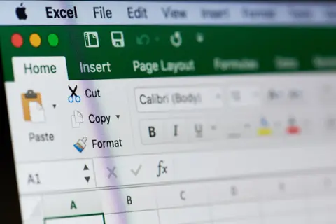 Ekran Excel z opcjami "Home", "Insert", "Cut", "Copy", "Paste". Widoczne ikony i przyciski do formatowania tekstu, ułatwiające blokowanie komórek Excel.
