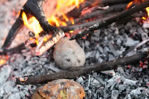 Kartoffeln garen im Glutbett. Ein rustikales Kartoffelfeuer-Rezept, das nach Sommer und Lagerfeuer schmeckt.