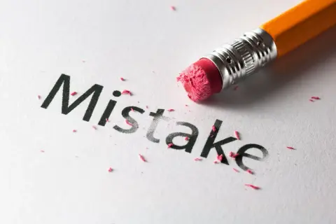 Gumka ściera słowo "Mistake", symbolizując **poka yoke** – system zapobiegający błędom.