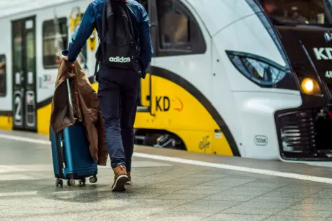 Pociąg nad morze z Krakowa czeka na pasażera z walizką.