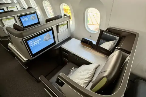 Luxuriöse Business-Class-Sitze von Eva Air. Die Bildschirme zeigen "Airplane Mode". Eine gute Eva Air Bewertung ist hier sicher!
