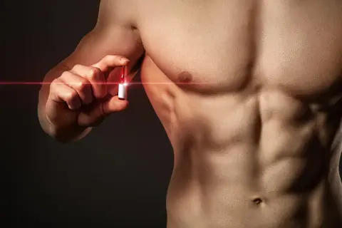 Mężczyzna z wyrzeźbionym torsem trzyma ampułkę, symbolizującą walkę z bigoreksją i dążenie do idealnego ciała.