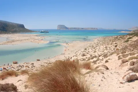 Piękne plaże na Krecie, Chania. Turkusowa woda, piaszczyste wybrzeże i góry w tle.