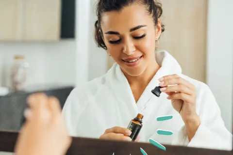 Frau im Bademantel nutzt ein Serum mit polyglutamic acid für strahlende Haut.