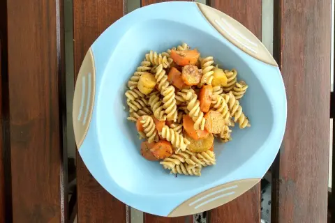 Zdrowy i kolorowy posiłek dla niemowlaka: makaron fusilli z marchewką i ziemniakami, doprawiony ziołami.