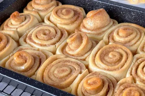 Frisch gebackene Zimtschnecken im Blech, bereit für das Zimtschnecken Rezept. Goldbraun und duftend, ein Genuss!