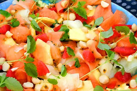 En färgglad melonsallad med ananas, passionsfrukt och nötter, perfekt som melonsallad till grillat.