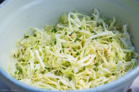 Frischer spitzkohl salat mit Schnittlauch und Chili-Flocken, appetitlich in einer Schüssel angerichtet.