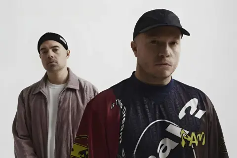 Dwóch mężczyzn w czapkach, jeden w sztruksowej kurtce, drugi w bluzie z napisem "Is this dream". Czy to zapowiedź problem koncertów 2025?