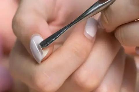 Manicure con attrezzo per cuticole, un passo fondamentale per imparare come fare le unghie in gel a casa e ottenere un risultato professionale.