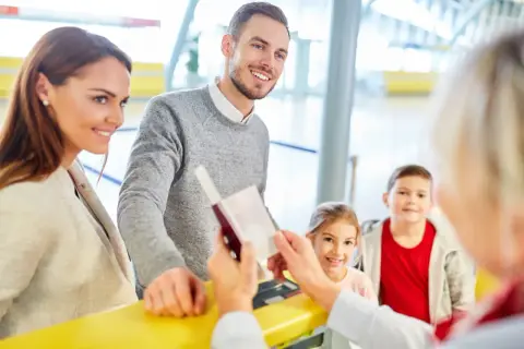 Rodzina na lotnisku, ojciec podaje paszport. Czy do Turcji potrzebny jest paszport? Tak, do podróży do Turcji potrzebny jest paszport.