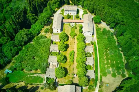 Vista aerea dell'eremo di San Giorgio, un complesso di edifici circondato da un rigoglioso bosco.