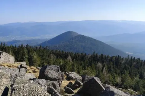 Vue panoramique depuis le rocher de Mutzig, avec une forêt dense et une montagne conique en arrière-plan.