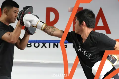 Two boxers train in a ring, one holding pads for the other's punch. This image shows the dedication required to reach advanced boxing levels.