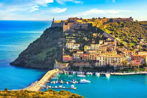 Porto Azzurro, un gioiello da scoprire tra le cose da visitare in Toscana. Un borgo colorato con un porto turistico e un'antica fortezza sul promontorio.