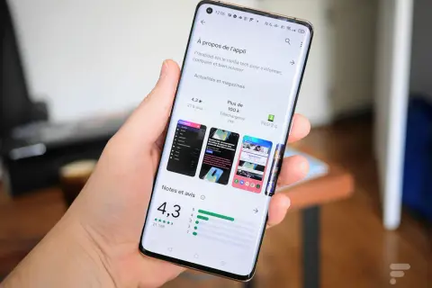 Main tenant un smartphone Samsung, affichant la page d'une application sur le Play Store, prêt à mettre à jour une application.