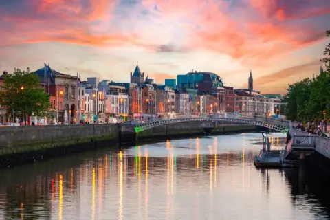 Zachód słońca nad rzeką Liffey, gdzie jest Dublin. Widać most Ha'penny i kolorowe kamienice.