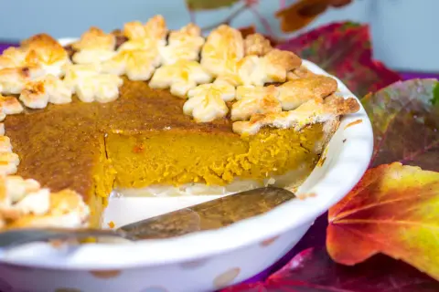 Ein leckerer Kürbiskuchen, dekoriert mit Blätter-Ausstechern, perfekt für Halloween.