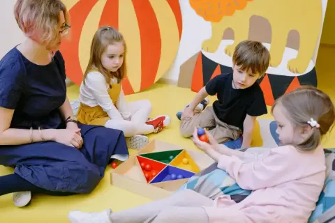 Dzieci z zaburzeniami czucia głębokiego ćwiczą koordynację, bawiąc się kolorowymi kulkami.