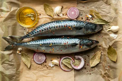 Två hela makrillar med kryddor, lökringar, vitlök och olja. Makrill nyttigt och gott att tillaga!