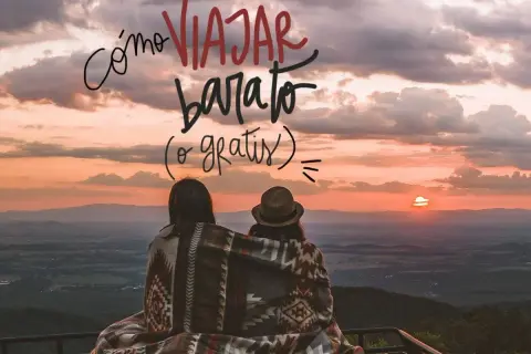 Dos personas comparten una manta viendo un atardecer. El texto dice "Cómo viajar barato (o gratis)".